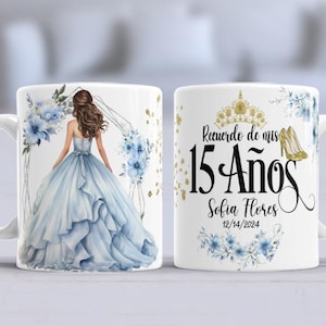 May include: White ceramic mug with a blue and gold design. One side features a drawing of a woman in a blue gown with a floral crown. The other side has the text "Recuerdo de mis 15 Años Sofia Flores 12/14/2024".