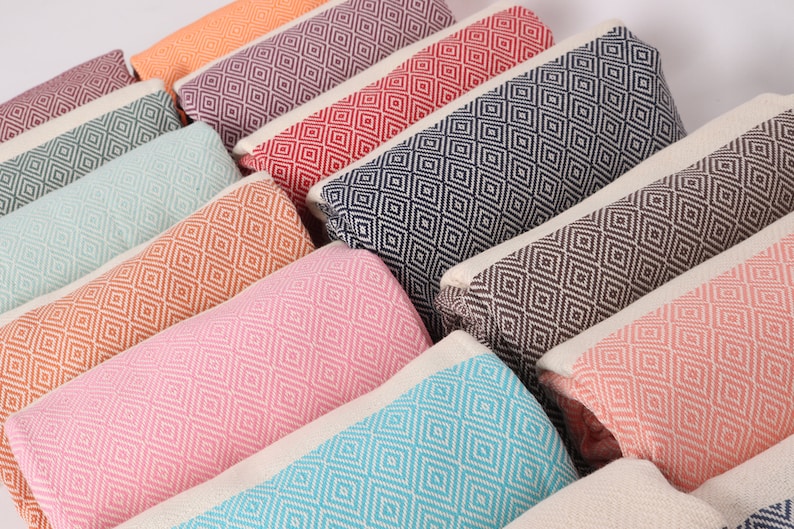 May include: A collection of colourful patterned throw pillows with a diamond pattern. The pillows are arranged in a row, with the colours ranging from orange to pink to blue.