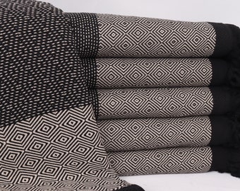 May include: A stack of six black and white patterned towels with fringed edges. The towels have a geometric diamond pattern.