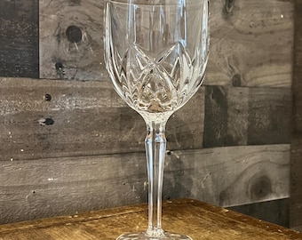 Può includere: Un calice da vino in vetro trasparente con un design in cristallo tagliato. Il calice ha un gambo alto e una coppa larga.