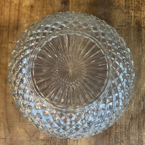 May include: A clear glass bowl with a diamond pattern on the exterior. The bowl has a raised, textured center.