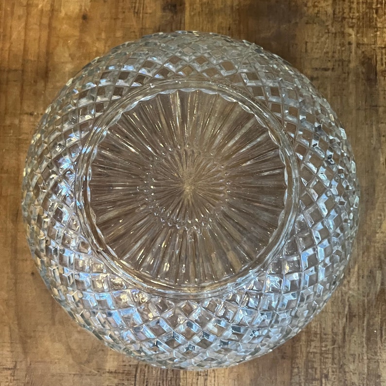 May include: A clear glass bowl with a diamond pattern on the exterior. The bowl has a raised, textured center.