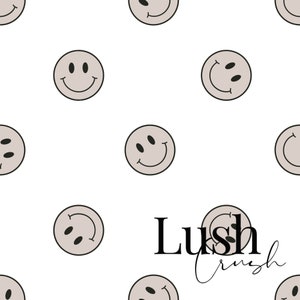 May include: A white background with a repeating pattern of light brown smiley faces. The text "Lush Crush" is in the centre of the image.