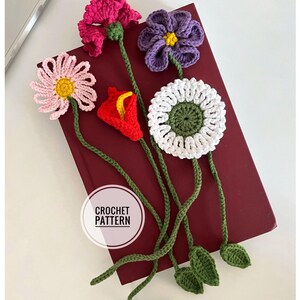 May include: A collection of handmade crochet flower bookmarks in various colors, including pink, purple, red, and white. Each bookmark features a different flower design with green stems and leaves. The text "CROCHET PATTERN" is visible.