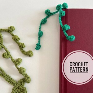 May include: A green crochet bookmark with a vine design and a round label that says "CROCHET PATTERN" is attached to a red book.