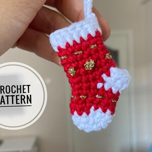 May include: A red and white crocheted Christmas stocking with gold glitter accents. The stocking is hanging from a loop and has a white cuff.