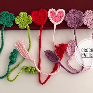 May include: Crocheted bookmarks in various shapes and colors, including green clovers, a red heart, and pink and purple flowers. Each bookmark has a long, braided cord. The text "CROCHET PATTERN" is visible.