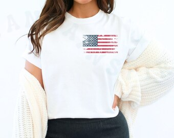May include: A white t-shirt with a distressed American flag graphic. The model is wearing black biker shorts and a white cardigan.