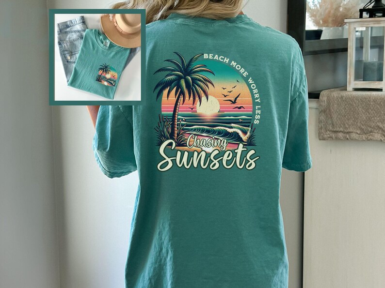 May include: Teal blue t-shirt with a graphic print of a palm tree, sunset, and ocean waves. The text "Beach More Worry Less" is above the graphic and "Chasing Sunsets" is below the graphic.