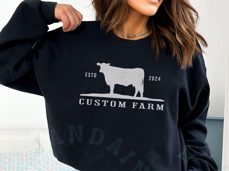 Puede incluir: Sudadera negra con una silueta blanca de una vaca y el texto "ESTD 2024 CUSTOM FARM".