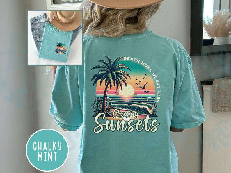 May include: A teal blue t-shirt with a graphic of a palm tree and sunset on the back. The text "Beach More Worry Less" is above the graphic and "Chasing Sunsets" is below the graphic.