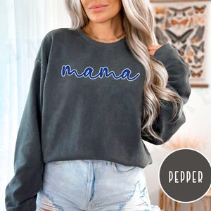 May include: A dark gray sweatshirt with the word "mama" written in blue cursive lettering.