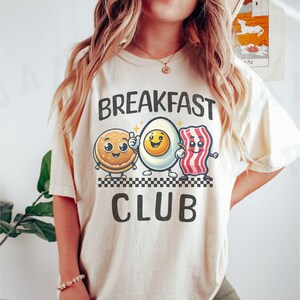 Maglietta del club per amanti della colazione, cibo, personaggio dei cartoni animati, maglietta carina, divertente, eccentrico, abbigliamento casual animato, maglietta unisex con pancetta e uova di pancetta stravaganti Ivory