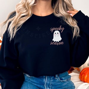 May include: Black sweatshirt with a white ghost graphic and the text "spooky season" in pink.