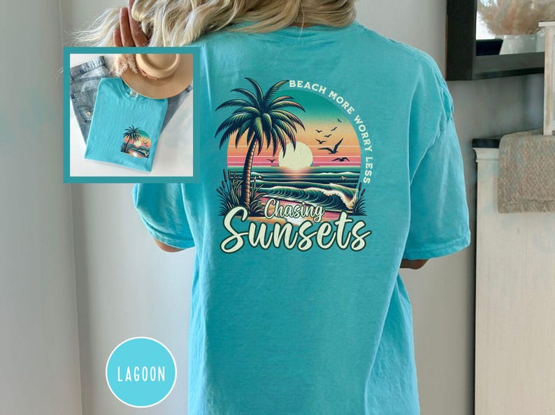 May include: A turquoise blue t-shirt with a graphic print of a palm tree, sunset, and ocean waves. The text "Beach More Worry Less" is printed in a circle around the graphic. The text "Chasing Sunsets" is printed below the graphic.
