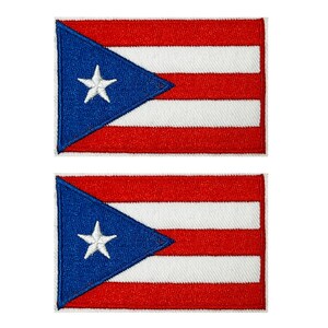 Könnte beinhalten: Zwei aufgestickte Aufnäher mit der Flagge von Puerto Rico. Jeder Aufnäher hat ein blaues Dreieck mit einem weißen Stern und abwechselnd rote und weiße horizontale Streifen.
