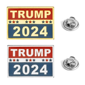 Può includere: Due spille rettangolari in smalto con la scritta "TRUMP 2024". La sezione superiore è rossa, il centro ha stelle blu e la parte inferiore è blu. Una spilla ha un bordo dorato, l'altra un bordo argentato. Ogni spilla ha un retro argentato.
