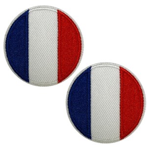 Peut inclure: Deux écussons ronds brodés représentant le drapeau français. Chaque écusson présente une bande verticale bleue à gauche, une bande blanche au centre et une bande rouge à droite. Les écussons ont une bordure blanche.