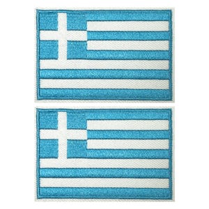 Könnte beinhalten: Zwei aufgestickte Aufnäher mit der griechischen Flagge. Jeder Aufnäher hat ein weißes Kreuz in der oberen linken Ecke und abwechselnd horizontale blaue und weiße Streifen. Die Aufnäher sind rechteckig mit einem weißen Rand.