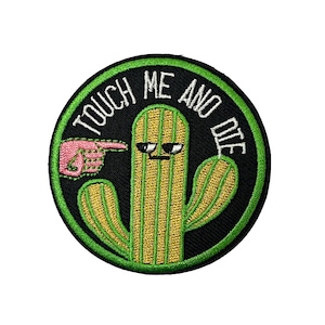 Könnte beinhalten: Gestickter Aufnäher mit einem Cartoon-Kaktus mit Sonnenbrille und dem Text "TOUCH ME AND DIE". Der Kaktus ist grün und gelb, vor einem schwarzen Hintergrund mit grünem Rand. Eine rosa Hand zeigt auf den Kaktus.