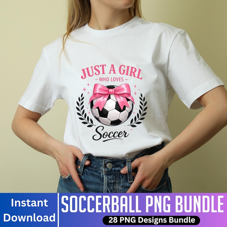 May include: White t-shirt featuring a soccer ball design with a pink bow and the text "JUST A GIRL - WHO LOVES - Soccer". The design is surrounded by laurel leaves. The shirt is worn with blue jeans.