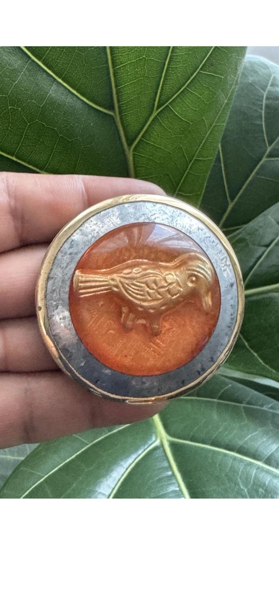 A tiny 1.25" bird art trinket box combining enameled resin and Tibetan brass — micro-scale artisan work with serious vintage-collector energy.