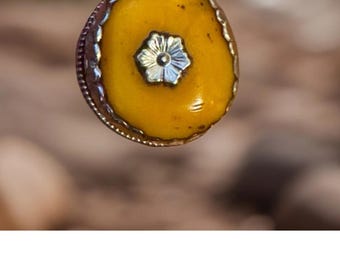 Pingente vintage e tradicional esculpido à mão em âmbar tibetano e baquelite, representando um auspicioso símbolo de pássaro, cravejado em prata tibetana. Mede 4,5 cm (1,8 polegadas) e pesa 15 gramas.