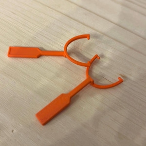 May include: Two orange plastic ring pull tools. The tools are designed to help open rings that are difficult to pull open by hand.