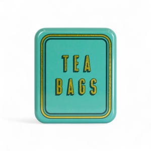May include: A teal metal tea bag storage tin with a gold border and the words "TEA BAGS" in gold block letters. The tin has rounded corners and a white background.