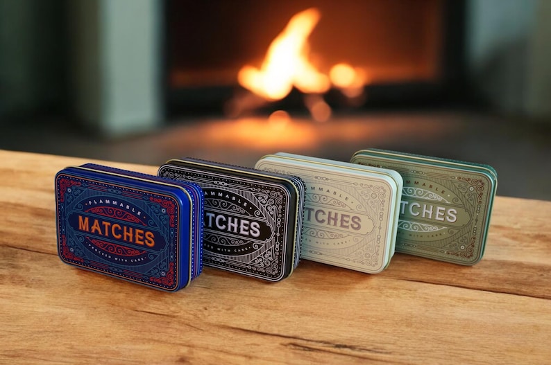 K&ouml;nnte beinhalten: Vier rechteckige Streichholzschachteln in einer Reihe, jede mit einer anderen Farbe und einem anderen Design. Die erste Schachtel ist blau mit dem Wort "MATCHES" in Orange. Die anderen Schachteln sind schwarz, hellgr&uuml;n und dunkelgr&uuml;n.