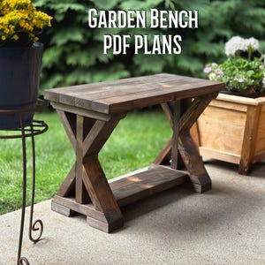 May include: A rustic wooden garden bench with a dark stain. The bench features an X-shaped support design and a lower shelf. The text "GARDEN BENCH PDF PLANS" is displayed at the top. The bench is outdoors, with greenery in the background.