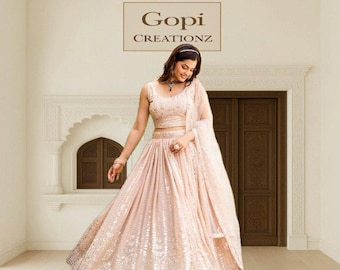 May include: A light pink, sleeveless, sequined lehenga with a matching crop top and dupatta. The outfit is worn by a person. The text "Gopi Creationz" is displayed in a rectangular box above the person.