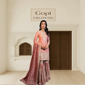 Könnte beinhalten: Ein hellrosa Salwar Kameez mit aufwendiger Stickerei und passendem Dupatta. Das Outfit hat ein langärmeliges Oberteil, eine ausgestellte Hose und silberne Akzente. Das Bild enthält den Text "Gopi Creationz".