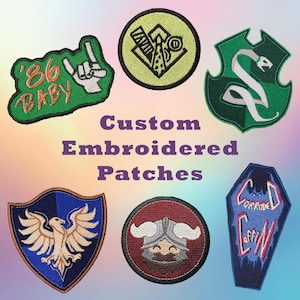 Może przedstawiać: Kolekcja niestandardowych, haftowanych naszywek w różnych kształtach i wzorach. Naszywki obejmują zieloną naszywkę z napisem "'86 BABY" i gestem dłoni, okrągłą naszywkę z wikingiem oraz tarczę z wężem.