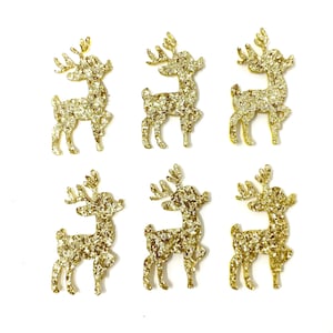 May include: Six gold glitter reindeer ornaments. The reindeer are all facing the same direction with their antlers up.