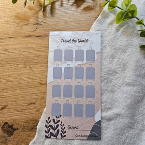 May include: A printable travel tracker with a watercolour background. The tracker features 20 suitcase icons to mark off destinations. The text "Travel the World" is at the top of the tracker. The text "Gesamt" is at the bottom of the tracker.