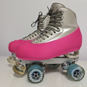 Op de afbeelding: Een paar zilveren rol schaatsen met roze laarzenhoezen en blauwe wielen. De wielen hebben het woord "Energica" erop gedrukt.