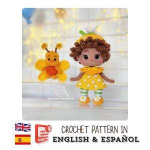 May include: A crochet doll with brown curly hair, wearing a yellow dress with white flower accents, green and white striped leggings, and yellow shoes, accompanied by a small yellow crochet butterfly with orange center and antennae.