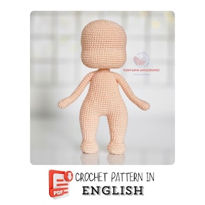 Puede incluir: Un cuerpo de muñeca tejido a ganchillo en color melocotón claro. La muñeca tiene cabeza redonda, brazos y piernas. La imagen incluye el texto "CROCHET PATTERN IN ENGLISH" y un icono PDF.