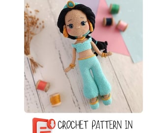 Könnte beinhalten: Häkelanleitung für eine Jasmine-Puppe auf Englisch. Die Puppe trägt ein türkisfarbenes Outfit mit goldenen Akzenten und hat lange schwarze Haare. Die Anleitung ist als PDF-Download verfügbar.