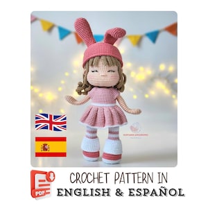 May include: A handmade crochet doll wearing a pink dress, hat, and boots. The doll has brown hair and is smiling. The image includes the text "CROCHET PATTERN IN ENGLISH & ESPAÑOL".