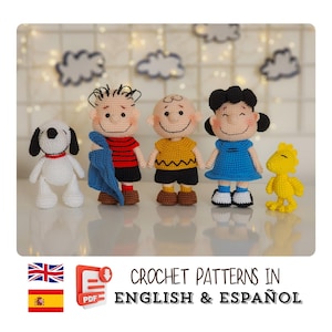 Op de afbeelding: Een verzameling gehaakte Peanuts-personages, waaronder Snoopy, Charlie Brown, Linus, Lucy en Woodstock. Elk personage is zorgvuldig gemaakt met levendige kleuren en gedetailleerde kenmerken. De tekst "CROCHET PATTERNS IN ENGLISH & ESPAÑOL" is ook aanwezig.