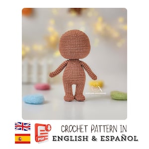 May include: A crocheted doll body in a brown color, with a rounded head, arms, and legs. The doll is standing upright. The image includes the text "CROCHET PATTERN IN ENGLISH & ESPAÑOL".