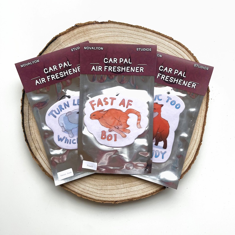 May include: Three car air fresheners with humorous animal illustrations and text. The first air freshener features a blue dog with the text "Turn Least AF". The second air freshener features an orange cat with the text "Fast AF Boi". The third air freshener features a red fox with the text "IC Too DY".