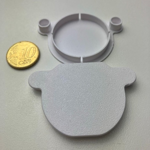 Front and back view of the cover, next to a 10 Cent coin for scale. The surface texture is well visible, and it imitates the original texture of IKEA cabinets quite closely.