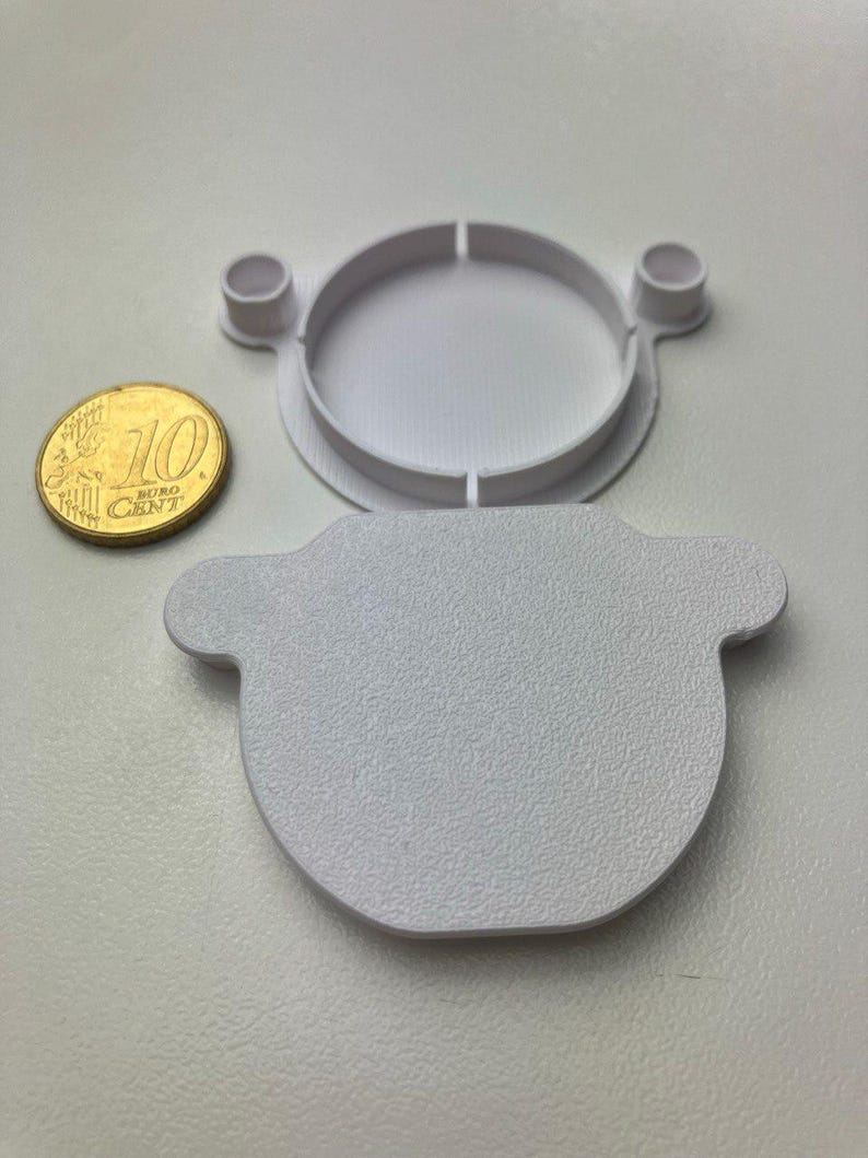 Front and back view of the cover, next to a 10 Cent coin for scale. The surface texture is well visible, and it imitates the original texture of IKEA cabinets quite closely.
