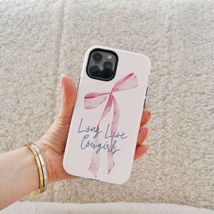 May include: A white phone case with a pink watercolor bow and the text "Long Live Cowgirls".