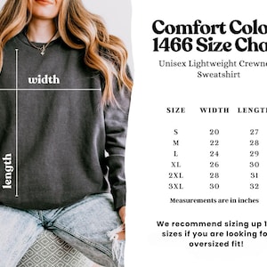 May include: A dark gray unisex crewneck sweatshirt with a size chart. The chart lists sizes S to 3XL, with width and length measurements in inches. The text recommends sizing up for an oversized fit.