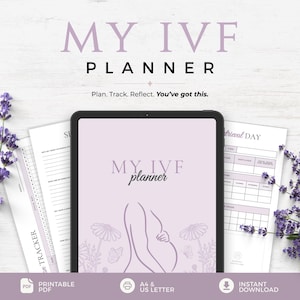 May include: A digital tablet displaying a light purple IVF planner cover with the text MY IVF planner and a line drawing of a pregnant torso, surrounded by printed planner pages and sprigs of purple lavender flowers on a white wood background.