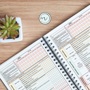 May include: A black and white planner with a spiral binding. The planner has sections for tracking emotions, thoughts, and skills. The planner also has a section for tracking daily habits and goals. The planner is open to a page with the title "Emotional Regulation".